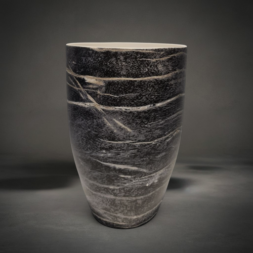 Black Wood Vase — tapered ceramic vase with a smooth glaze reading as charred wood grain, black and grey with pale streaks and a white rim, HMT Home