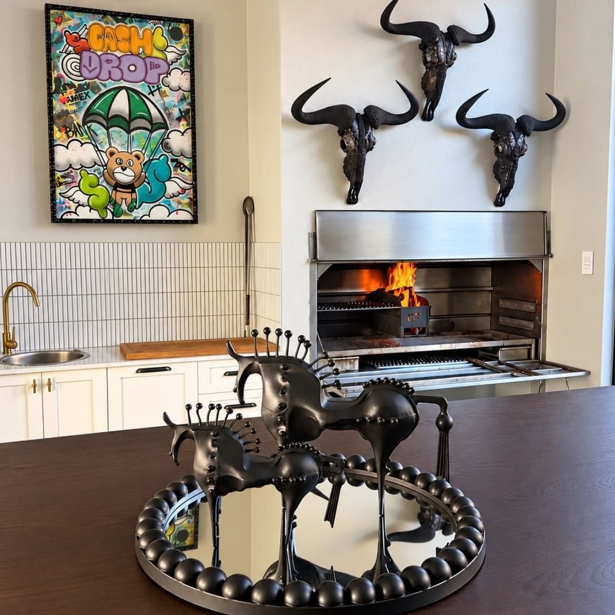 Nero Horse Sculptures large and small styled on a round mirrored tray on a dark kitchen island — stylised matte black horses with spined pin manes, HMT Home