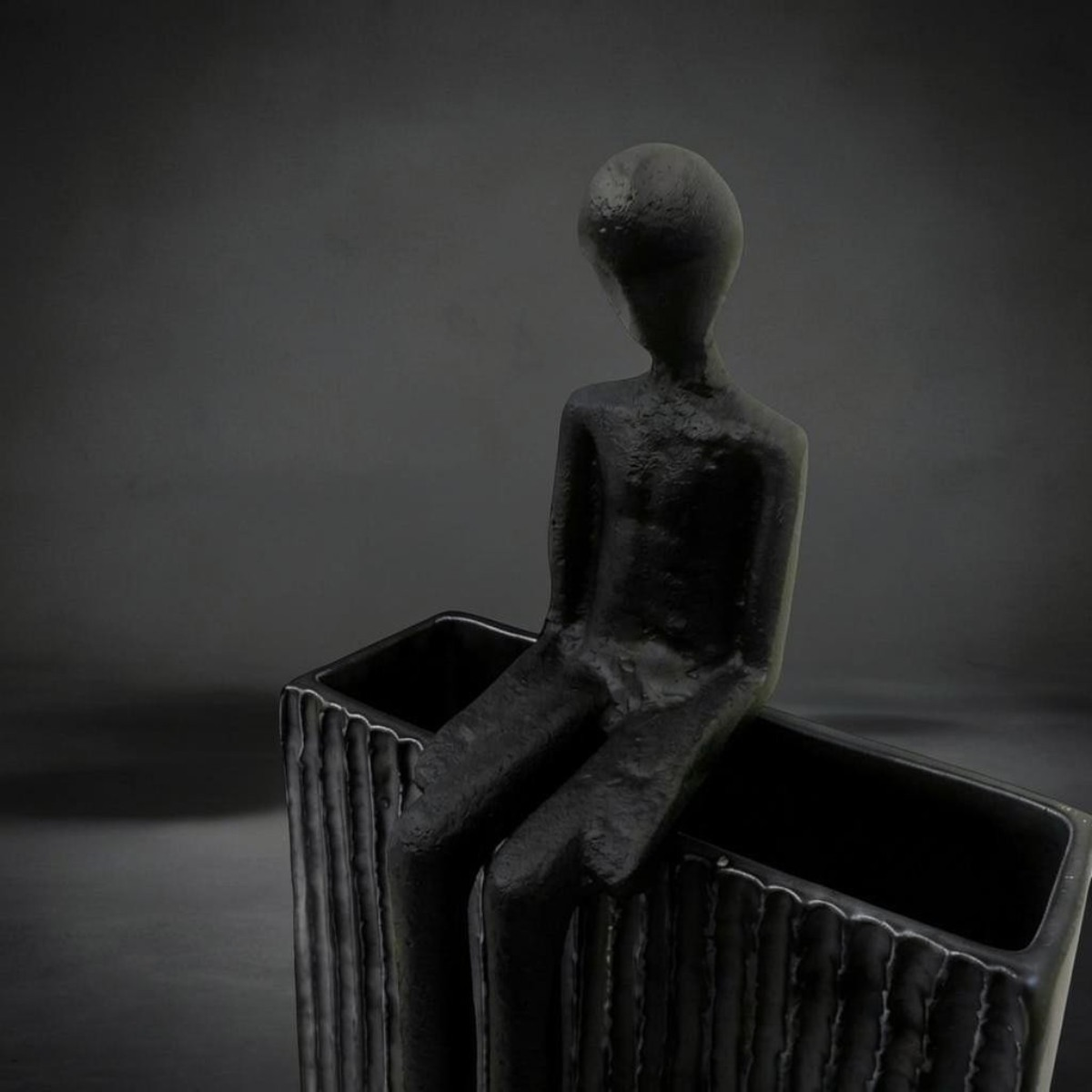 Seated Figure — slender dark sculpture with long legs, made to perch on a shelf edge, HMT Home